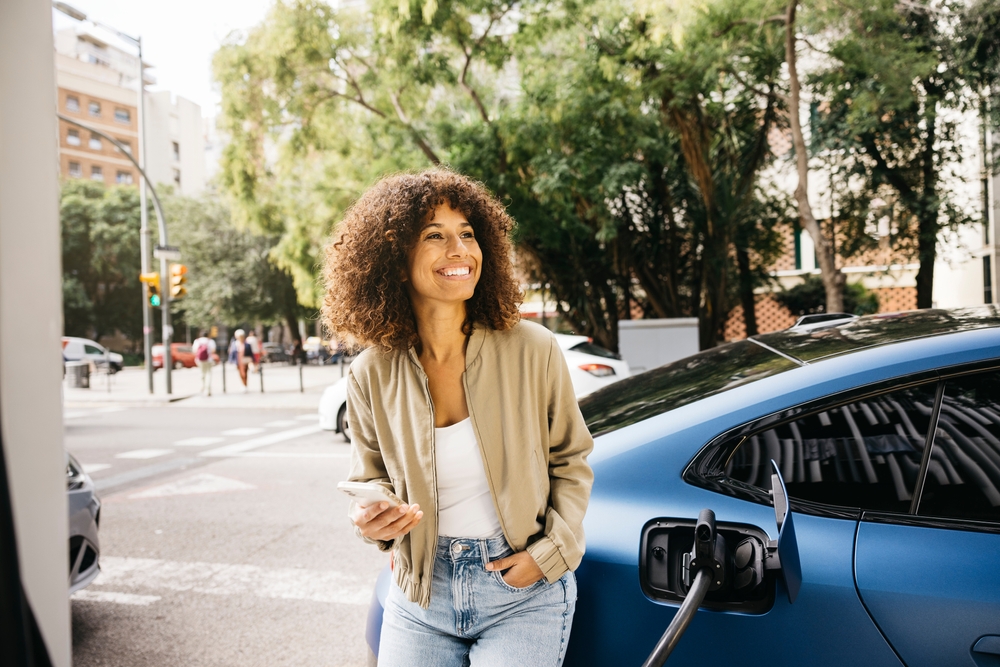 mujer sonriendo con coche electrico